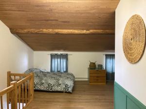 una camera da letto con un letto e un soffitto in legno di La maisonnée Auvergnate ad Auzelles