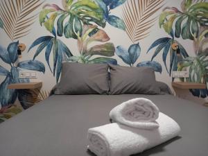 Un dormitorio con una cama con una toalla. en Casa Fénix en el centro de Andalucía en Roda de Andulucia