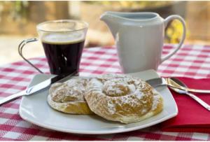 due ciambelle su un piatto vicino a una tazza di caffè di Casa Millor Vista, Rooms a Xàtiva