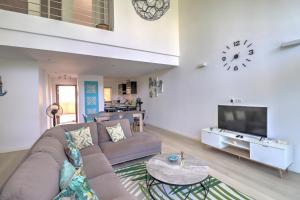 sala de estar con sofá y TV en Le Turquoise - Beachfront, en Cap Malheureux