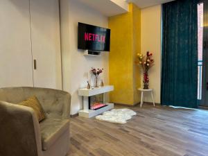 un soggiorno con divano e TV a parete di Suite Deluxe - Jacuzzi - Private Parking a Torino