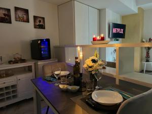 sala de estar con mesa de comedor con velas y flores en Suite Deluxe - Jacuzzi - Private Parking en Turín