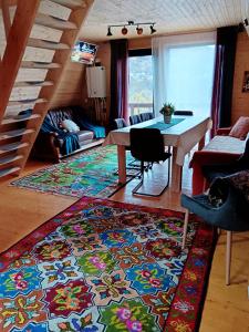 a living room with a table and a rug at CARPATINA Ruustic House in Runcu