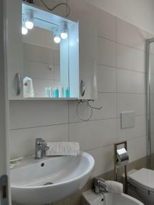 W łazience znajduje się umywalka, lustro i toaleta. w obiekcie Casa DaDi w mieście Sottomarina