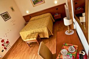 mały pokój z łóżkiem i stołem w obiekcie Hotel Picchio w mieście Orvieto