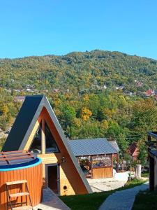 a house with a gambrel roof on top of it at CARPATINA Rustic House in Runcu
