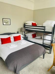 a bedroom with two bunk beds with red pillows at The Garret Hotel in Kirkcudbright