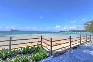 a beach with a wooden fence and the ocean at SG5 l Le Turquoise - third line building - Beachfront Residence in Cap Malheureux