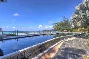 a swimming pool with the ocean in the background at SG5 l Le Turquoise - third line building - Beachfront Residence in Cap Malheureux