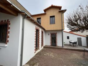 uma casa com paredes brancas e persianas vermelhas em Maison La Bernerie-en-Retz, 4 pièces, 6 personnes - FR-1-612-31 em La Bernerie-en-Retz