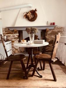 a table and two chairs with a vase on it at Bnbook Ca Du Val in Terrabona