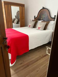 a bedroom with a large bed with a red blanket on it at Bnbook Ca Du Val in Terrabona