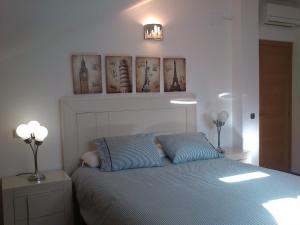 a bedroom with a bed with two blue pillows at Dúplex Isabel in Toledo