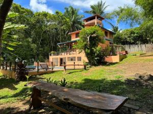 a house with a bench in front of it at Casa Amadou com grande piscina em Boipeba in Ilha de Boipeba
