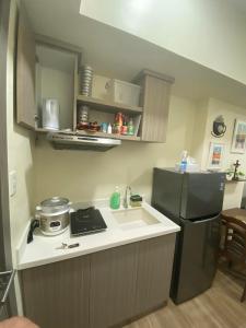 a small kitchen with a sink and a refrigerator at Northwoods Place Studio Unit in Mandaue City