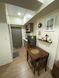 a living room with a table and a kitchen at Northwoods Place Studio Unit in Mandaue City