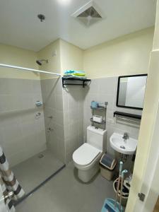 a bathroom with a toilet and a shower and a sink at Northwoods Place Studio Unit in Mandaue City
