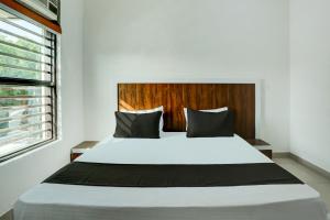 a bedroom with a large white bed with a wooden headboard at OYO Hotel Rajhans in Gurgaon
