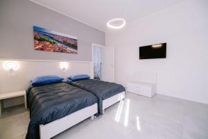 a white bedroom with a bed and a tv at Residenza La Boheme in Verona