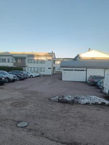 a parking lot with cars parked in front of a building at Lägenhet på markplan in Mariehamn