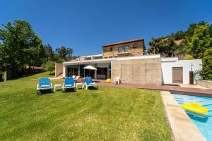 une cour avec deux chaises et une piscine dans l'établissement Casa de Silvares Fafe - Moradia Premium com piscina by House and People, à Regadas