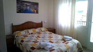 une chambre avec un lit avec une couette dessus dans l'établissement hostal restaurante galicia, à Villardefrades