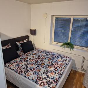 Solace Apartment, Oslo Downtown في أوسلو: غرفة نوم عليها سرير ولحاف ورد