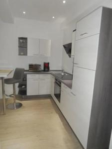 uma cozinha com um frigorífico branco e uma mesa em Calla Apartment 3 em Wolfsburg