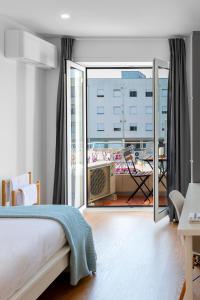 a bedroom with a bed and a large balcony at East River - T4 junto ao Altice Forum - Braga in Braga