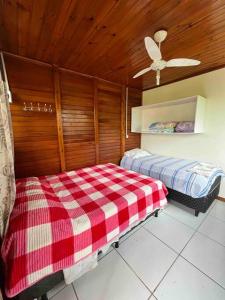 a room with two beds and a ceiling fan at Bem vindos a Vila da Paz Itaara in Itaara +24 photos
