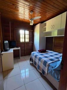 ein Schlafzimmer mit einem Bett und einem Fernseher in einem Zimmer in der Unterkunft Bem vindos a Vila da Paz Itaara in Itaara