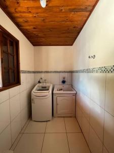 Waschmaschine und Trockner in einem kleinen Bad in der Unterkunft Bem vindos a Vila da Paz Itaara in Itaara + 21 Fotos