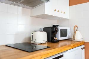 a kitchen counter with a microwave and a toaster at Studio Chaleureux niché au cœur des Salins in Arles