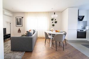 ein Wohnzimmer mit einem Sofa und einem Tisch in der Unterkunft João da Ponte - T1 Altice Forum Braga by House and People in Braga
