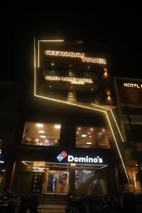 een bord aan de zijkant van een gebouw 's nachts bij Green Valley Luxurious Hotel in Ghaziabad
