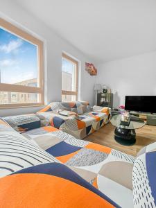 uma sala de estar com sofás e uma televisão e um quarto com em La Petite Pépite d'Ostwald em Ostwald