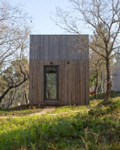 une petite maison en bois sur une colline avec des arbres dans l'établissement Refugio do Carrascal, à Tomar