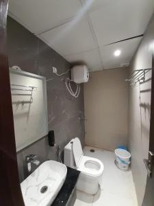 een badkamer met een wit toilet en een wastafel bij Green Valley Luxurious Hotel in Ghaziabad