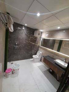 een kleine badkamer met een toilet en een wastafel bij Green Valley Luxurious Hotel in Ghaziabad