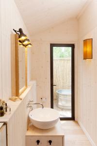 Baño blanco con lavabo y bañera en Glamping Terre di Sacra in Tuscany, en Capalbio