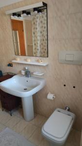 La salle de bains est pourvue d'un lavabo, de toilettes et d'un miroir. dans l'établissement Val Del Vent - Ideale per Coppie, à Brusino