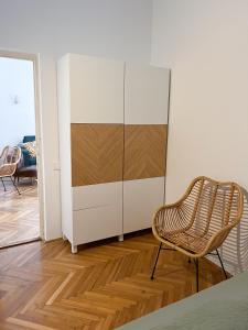 ブダペストにあるHome in the centre of Budapestの白いキャビネットと椅子が備わる客室です。