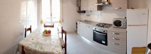 una cucina con tavolo e una cucina con piano cottura di Casa Massimo a Moneglia
