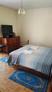 - une chambre avec un lit et une commode avec une télévision dans l'établissement Val Del Vent - Ideale per Coppie, à Brusino