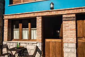 een gebouw met een houten deur en een tafel bij apartamentos rurales marrubiu-playa de Poo in Llanes