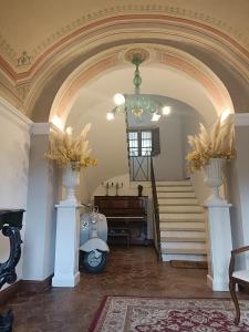 a hallway with an archway with a piano and vases at B&B - La Corte D'Ivi in Collepardo