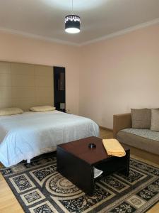 1 dormitorio con cama, sofá y mesa en luxe appartement marina en Agadir