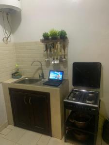 una cocina con un ordenador portátil en una encimera junto a una estufa en diallo appartement1 en Ngor