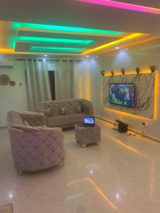 sala de estar con 2 sofás y TV de pantalla plana en diallo appartement1 en Ngor