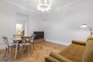 ロンドンにあるStylish Kensington Courtyard Apartmentのリビングルーム(ソファ、テーブル、椅子付)